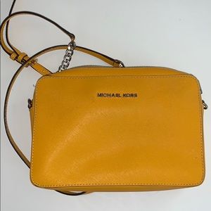 Yellow crossbody Michael Kors purse.